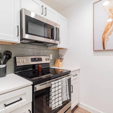 Kitchen featuring decorative backsplash, light cou