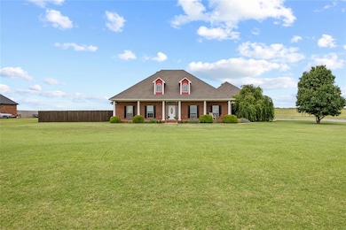 View of front of house featuring brick siding, covered porch, and a shingled roof