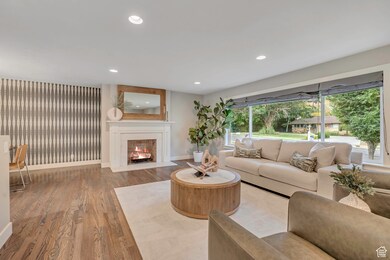 Living area featuring light wood-type flooring, recessed lighting, and a fireplace with flush hearth