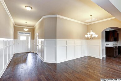 The open dining room has 60 inch craftsman style wainscoting, scraped hardwood flooring, and crown molding.