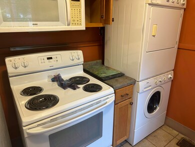 Kitchen with white appliances, light tile patterne