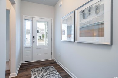 Doorway to outside featuring baseboards and dark w