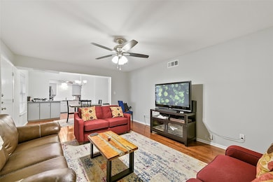 Living room featuring ceiling fan with notable cha