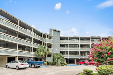 View of apartment building / complex featuring uncovered parking