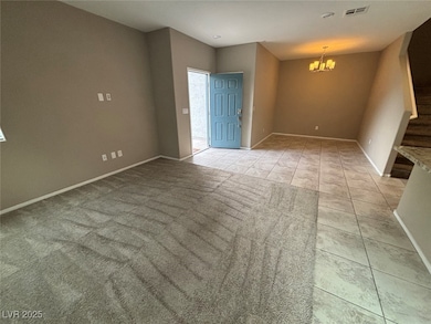 Empty room with stairway, a chandelier, and light tile patterned flooring