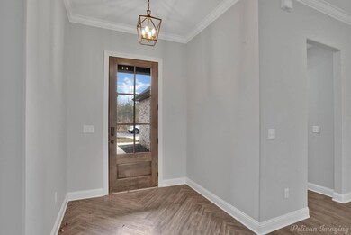 Foyer with dark parquet flooring, crown molding, a