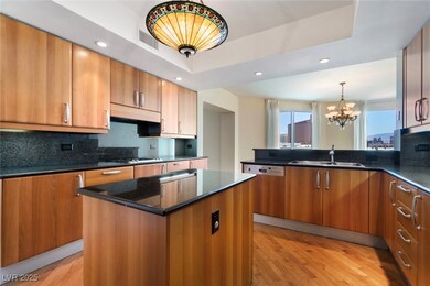 Kitchen featuring a sink, a chandelier, brown cabi