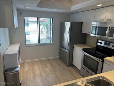 Kitchen featuring white cabinetry, light hardwood