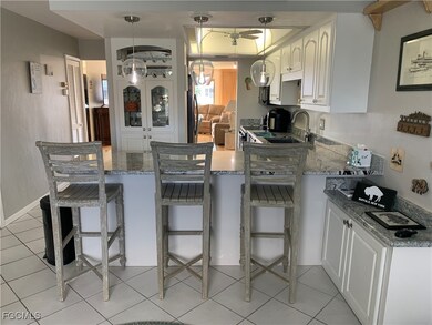Kitchen featuring white cabinets, pendant lighting, a breakfast bar area, and sink