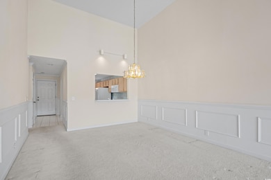 Carpeted spare room featuring a decorative wall, a