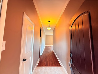 Hallway featuring ornamental molding and tile patterned floors