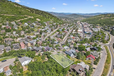 Aerial view of property and surrounding area with property boundaries highlighted and a mountain backdrop