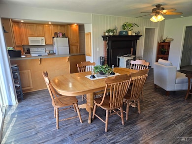 Dining area featuring dark wood-type flooring and a ceiling fan