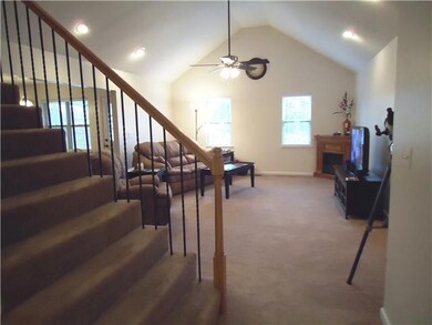 A beautiful staircase with wrought iron spindles opens to the living room and  leads to the spacious upstairs. 