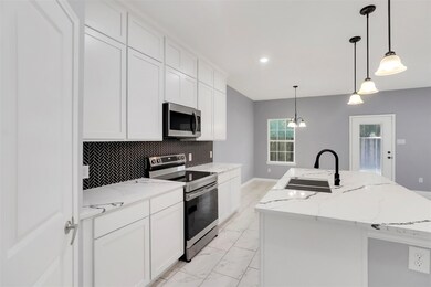 Kitchen featuring hanging light fixtures, backspla