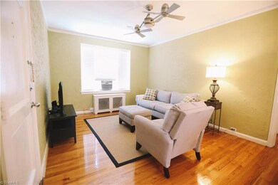 Living room has ceiling fans, crown moulding, tons of natural light, and hardwood floors.
