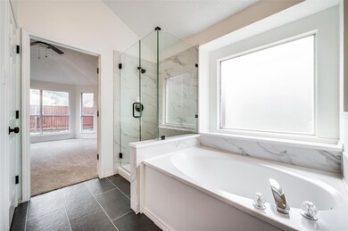 Bathroom featuring a textured ceiling, plus walk i