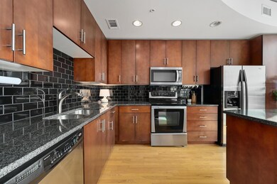 Kitchen with stainless steel appliances, light wo