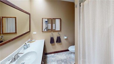 Bathroom with vanity, mirror, and light tile floor