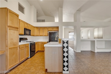 Kitchen with gas range, black microwave, freestand