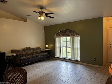Living room with ceiling fan, light tile patterned