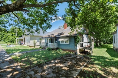 View of front of property with a chimney and a front yard
