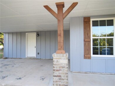 Brick and cedar support poles with matching shutters.