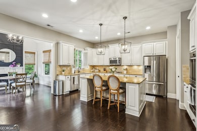 The Chef's Kitchen is truly made for entertaining, with a huge Granite Island, White Cabinets, Stainless Steel Appliances, Double Ovens, and a spacious Walk-In Pantry.
