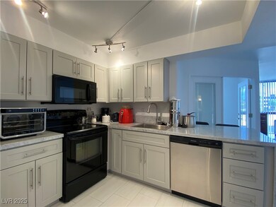 Kitchen with black appliances, a peninsula, light