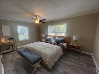 Bedroom featuring baseboards, wood finished floors