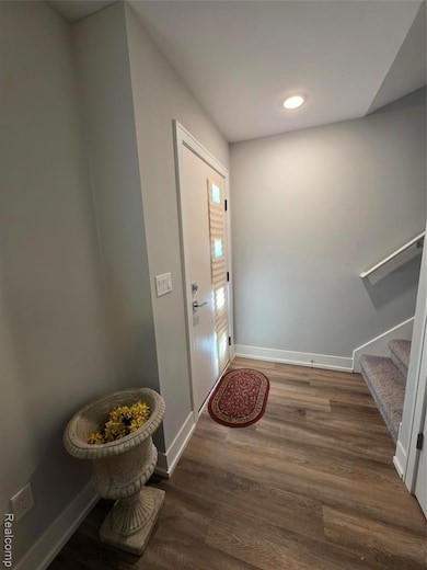 Entrance foyer with stairway, dark wood-style flooring, and recessed lighting
