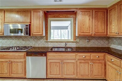 Kitchen sink window overlooks sunroom which overlo