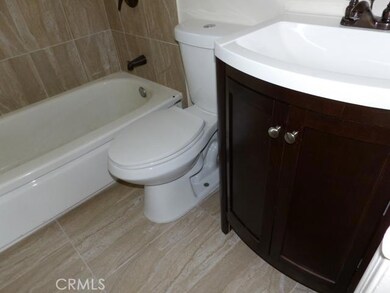 Remodeled bathroom with new tiles, new vanity, new bronze fixtures and new toilet.