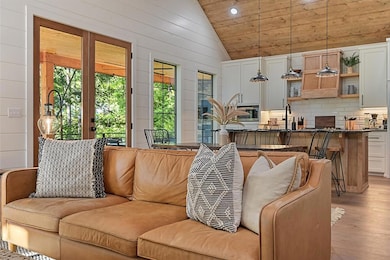 Living room with high vaulted ceiling, light wood-