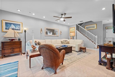 Living area featuring ceiling fan, recessed lighting, stairway, and light tile patterned flooring