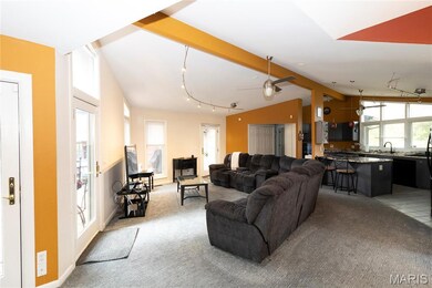 Living area featuring light carpet, ceiling fan, and rail lighting