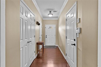 Doorway featuring ornamental molding and hardwood / wood-style flooring