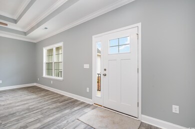 Entrance foyer with light hardwood / wood-style floors and ornamental molding