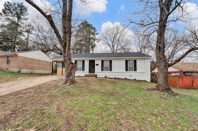 Single story home with a front lawn and a carport