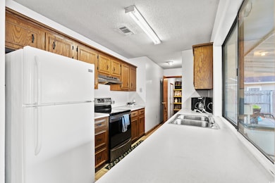 Kitchen featuring white refrigerator, stainless st