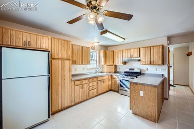 Kitchen featuring refrigerator, sink, ceiling fan,