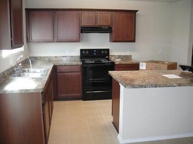 Kitchen featuring light tile flooring, light stone countertops, sink, ventilation hood, and electric stove