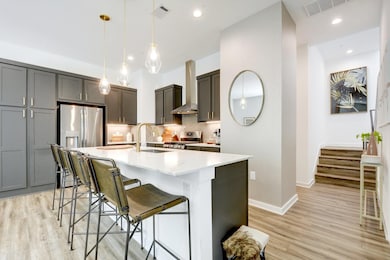 Modern chef’s kitchen featuring quartz counters, large island with seating, and abundant cabinetry.