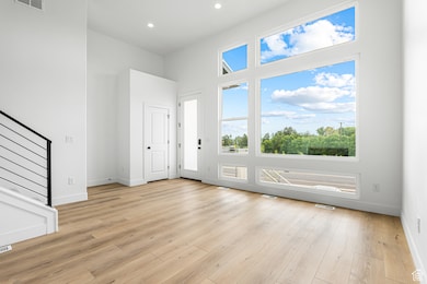 Entrance foyer with light wood finished floors, recessed lighting, and stairs