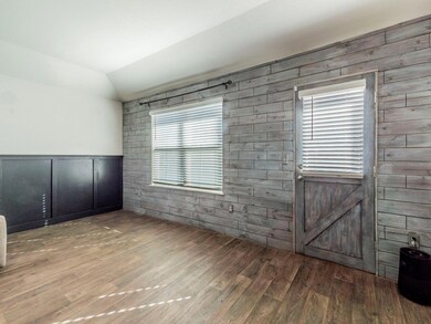Spare room with lofted ceiling and wood finished floors