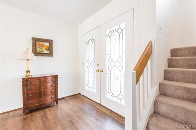 Foyer with hardwood floors and leaded glass doors.