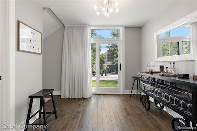 Flex space with hardwood / wood-style flooring and a chandelier