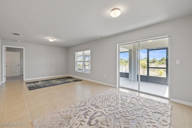Empty room with light tile patterned floors, visible vents, and baseboards