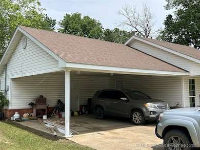 View of parking / parking lot featuring a carport
