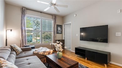 Living area featuring baseboards, a textured ceili